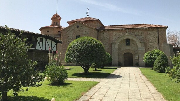 A historic building with a central arched entrance, a bell tower, and a symmetrical facade. - Casa Rural La Lagunilla Golf (Candeleda)