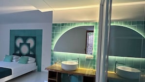 A modern bathroom with two sinks, a large mirror, and a shower area.