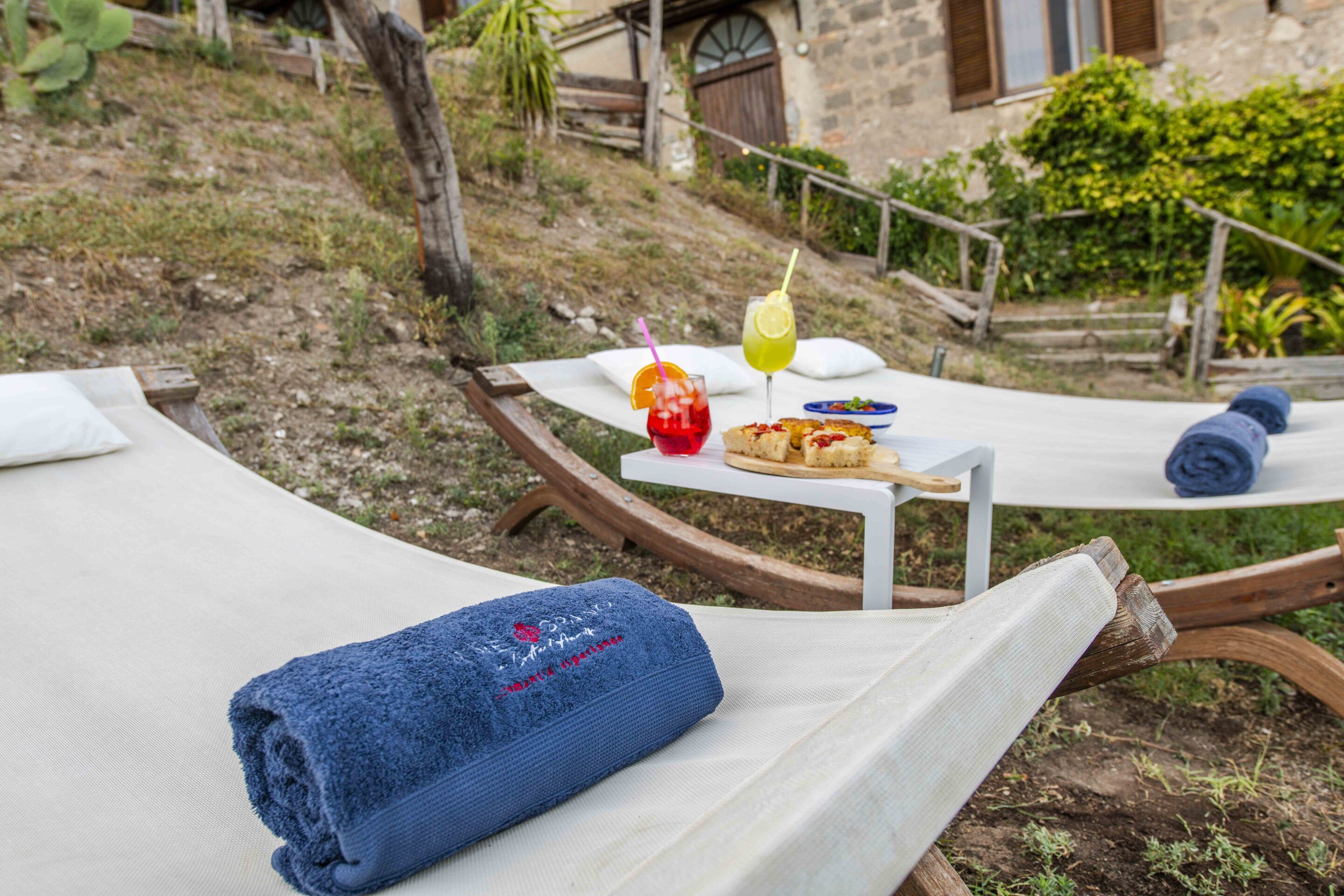 A sunlit outdoor dining area with a table set for two, including a meal and drinks.