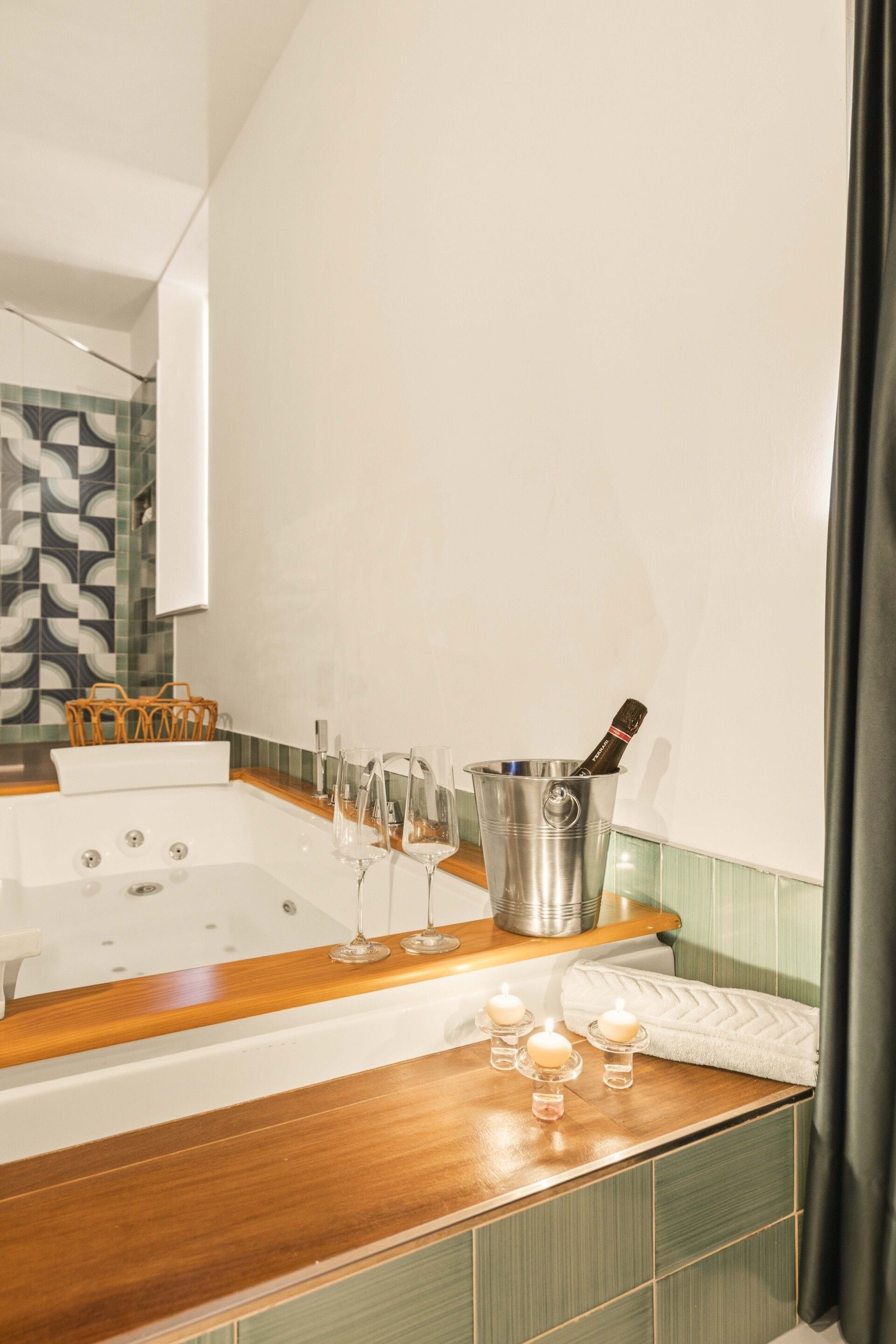 A bathroom with a wooden vanity, a bathtub, and a glass container with a bottle.