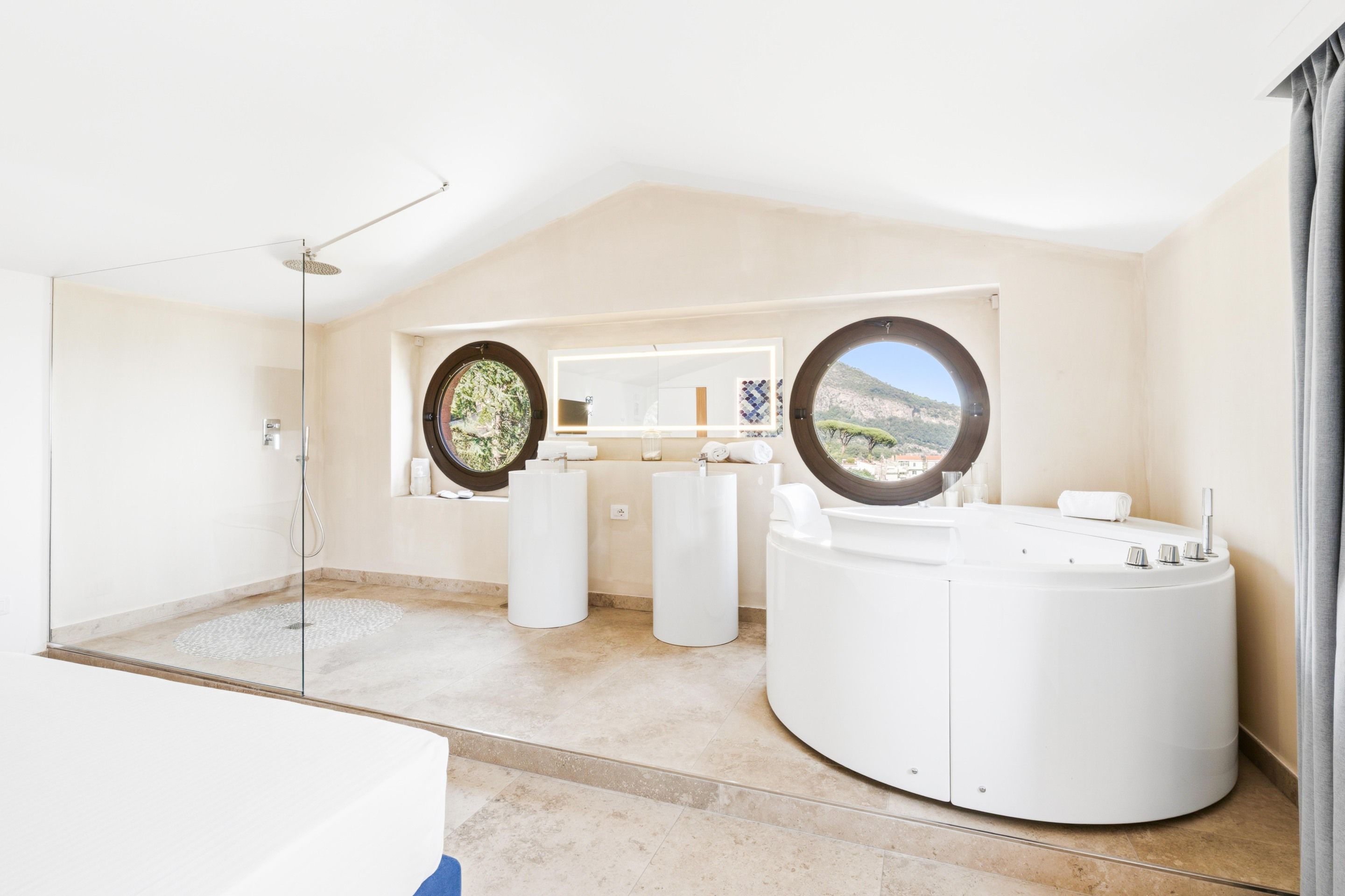 A modern bathroom with a large bathtub, two sinks, and a shower.