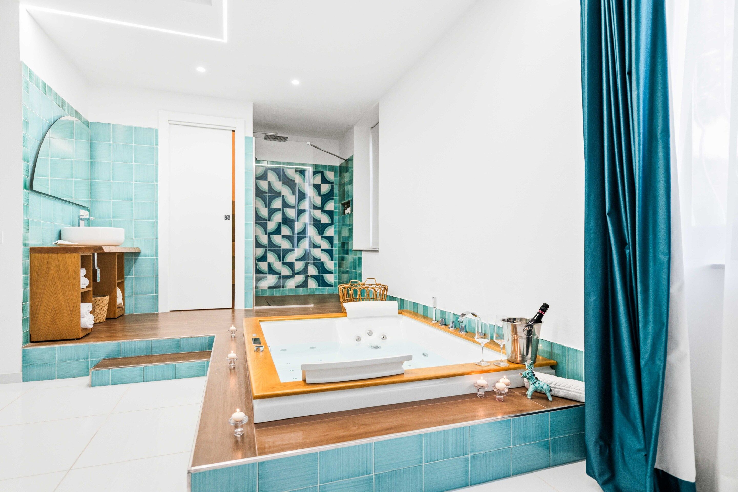 Une salle de bain moderne avec une baignoire sur pieds, un meuble-lavabo et un espace douche agrémenté de carreaux à motifs.