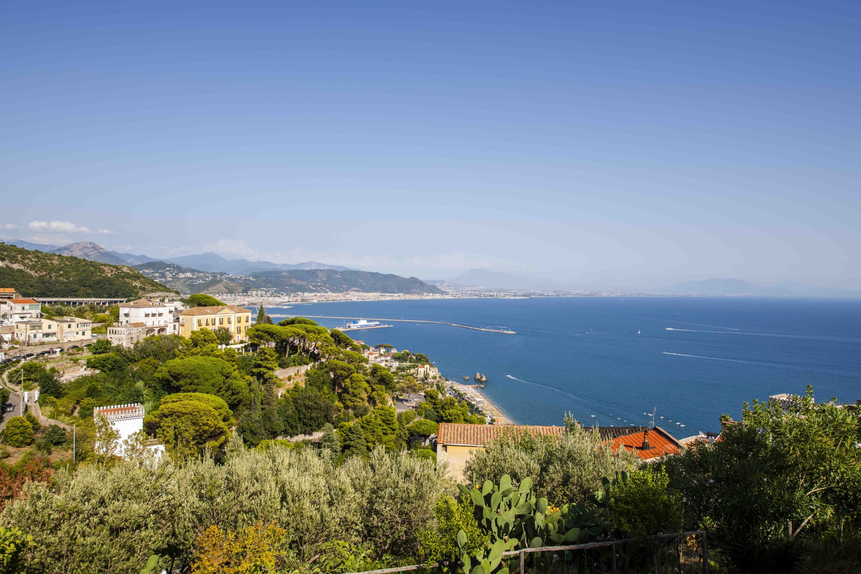 A coastal town with buildings, a beach, and a view of the sea.