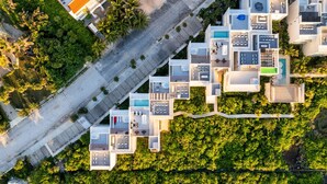 An aerial view of a modern hotel with multiple interconnected buildings, a swimming pool, and lush greenery surrounding the property. - Seaside Penthouse! Rooftop Jacuzzi & Ocean Views! (Tulum Municipality)