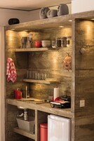 Una cocina con salpicadero de concreto, electrodomésticos de acero inoxidable y diversos utensilios de cocina.