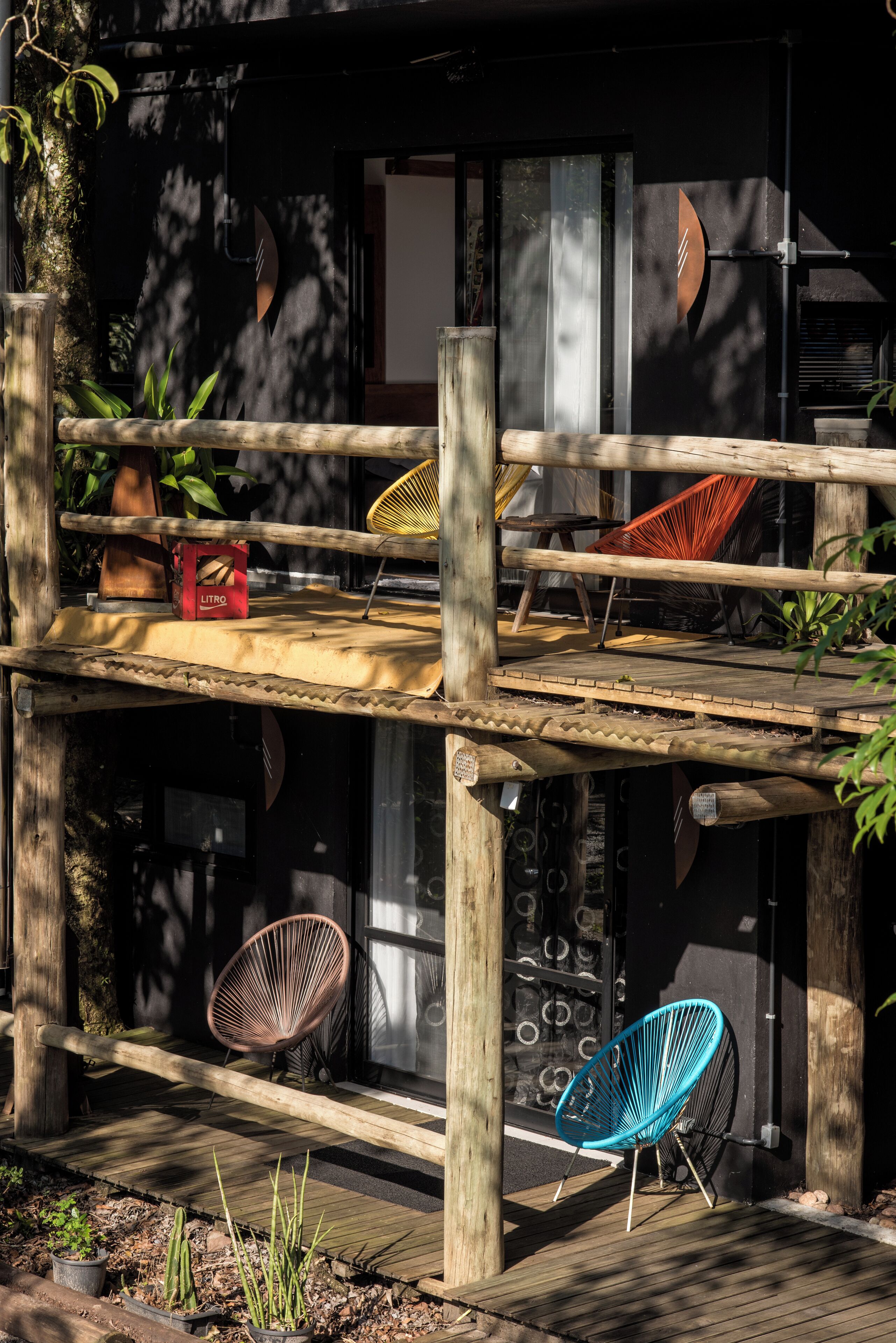 A wooden deck with two chairs and a hammock.