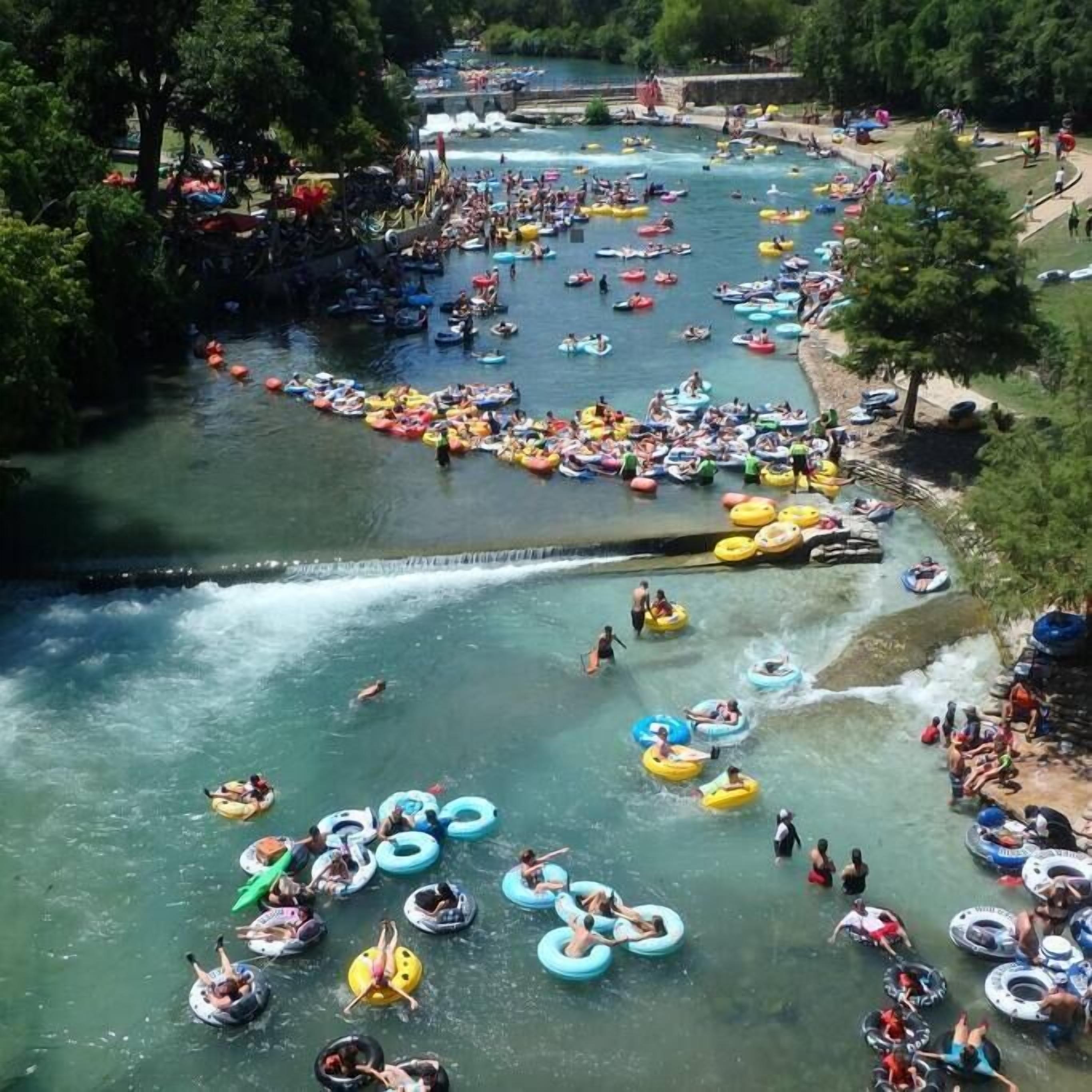 Un río con varias personas flotando en flotadores y balsas.