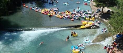 Un río con varias personas flotando en flotadores y balsas.