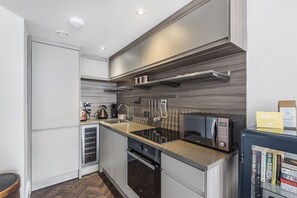 Enjoy cooking in this well-equipped kitchen with a microwave, stainless steel range hood, and coffee maker.