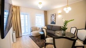 A modern living room with a sofa, chairs, a dining table, and a plant. - Villa Pupin SARAISTE (Ohrid)