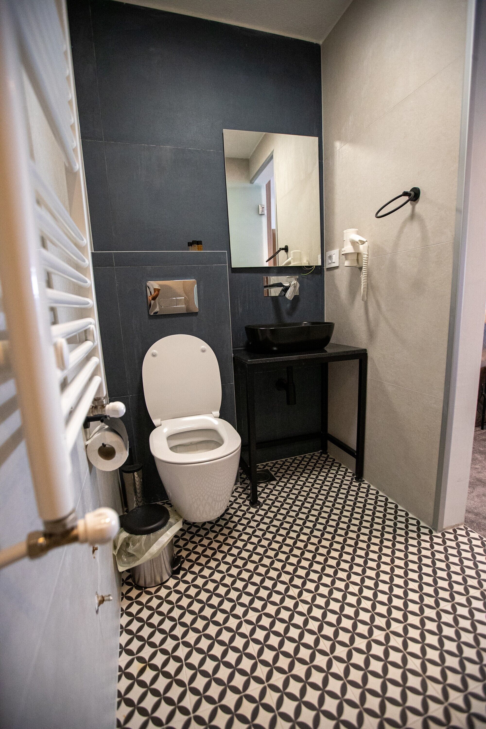 Un baño con inodoro, lavamanos y espejo.