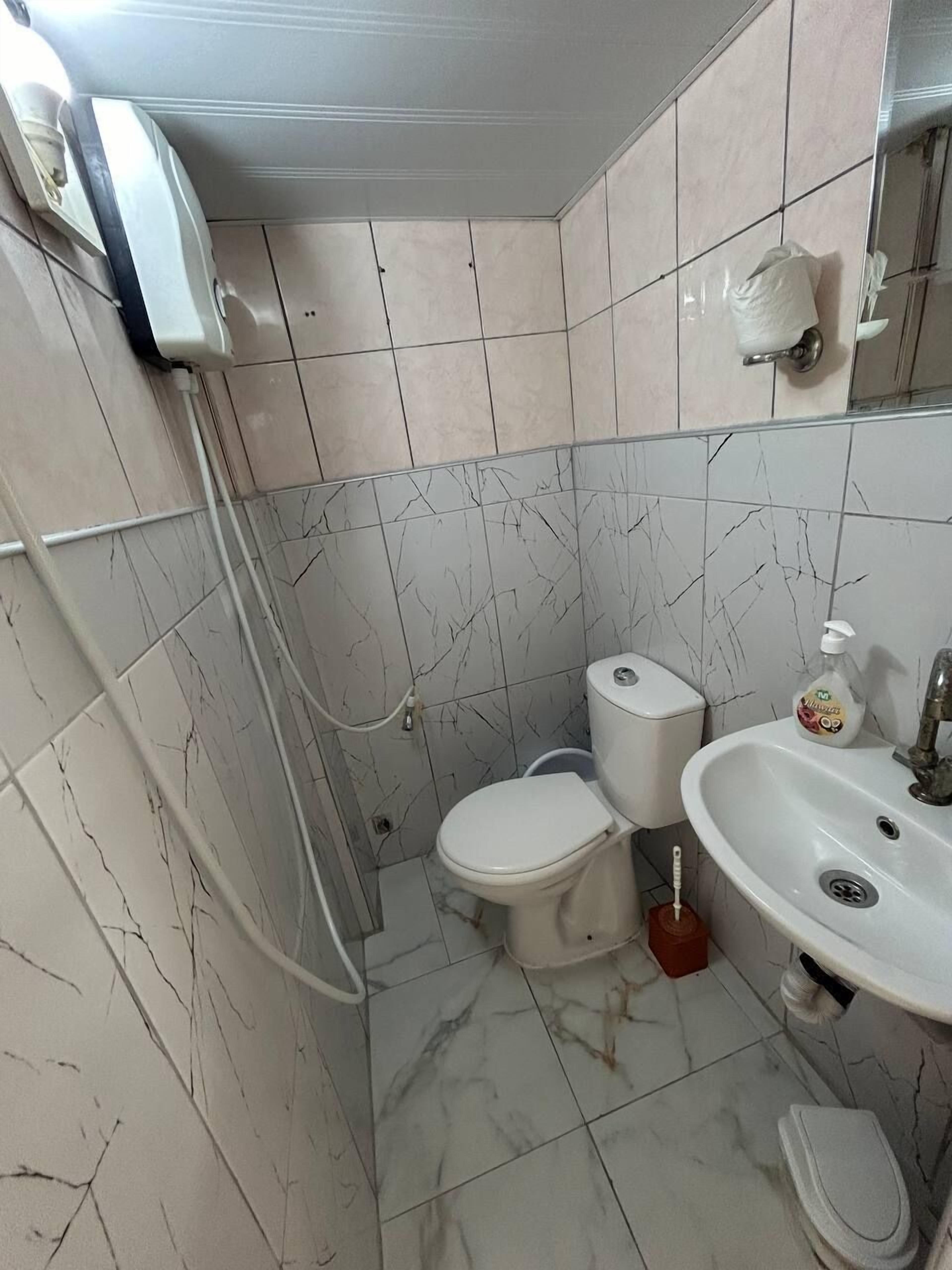 A bathroom with a toilet, bidet, and sink.