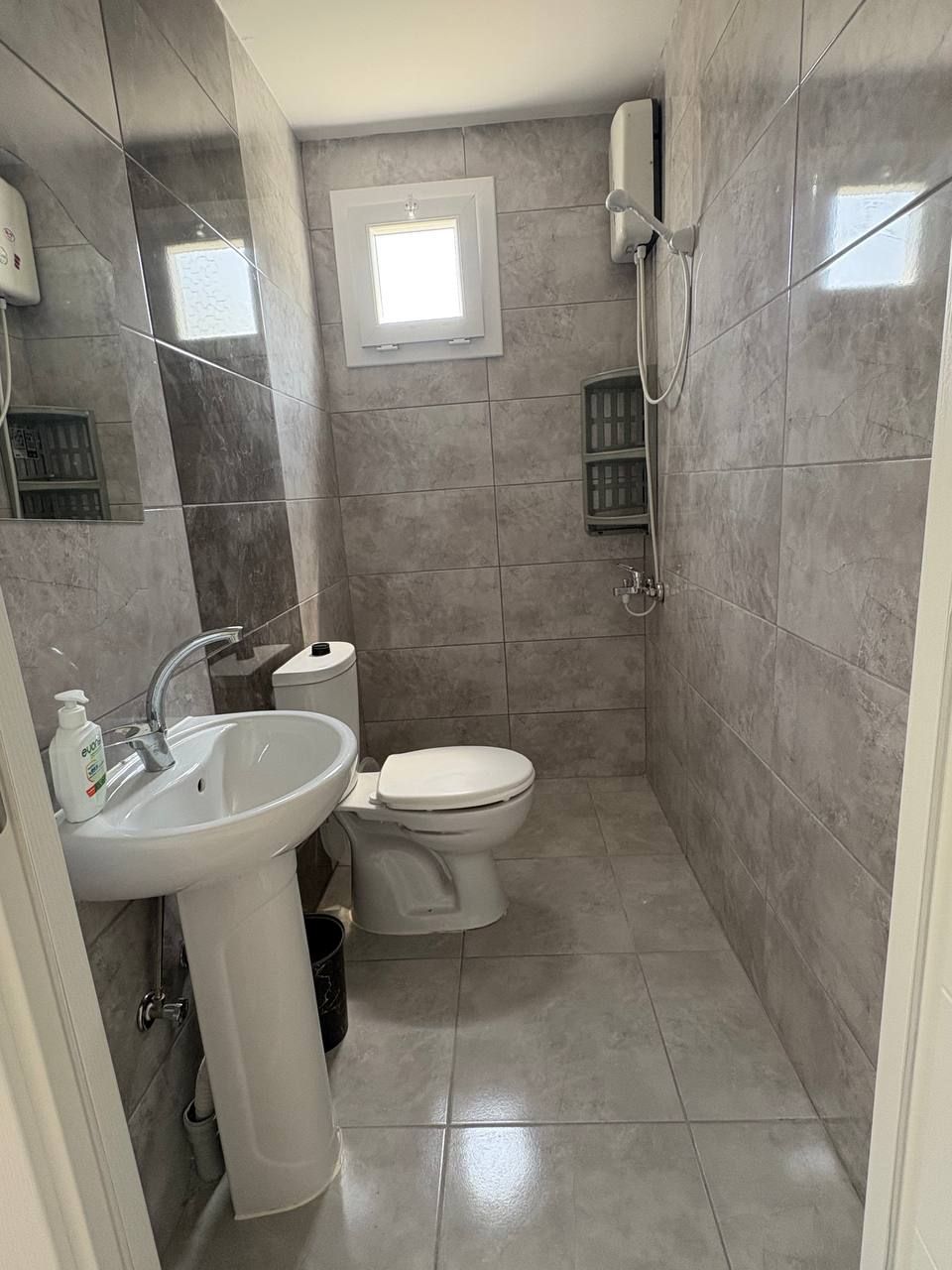 A bathroom with a sink, toilet, and shower.