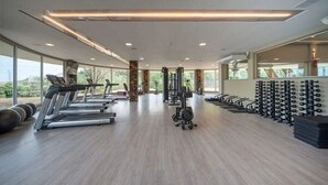 A modern gym with treadmills, weight machines, and a wall of dumbbells. - Golden Gramado Laghetto Resort - MC (Gramado)