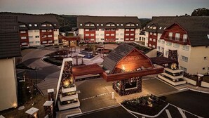 A hotel with multiple buildings, a central courtyard with a fountain, and outdoor seating areas. - Golden Gramado Laghetto Resort - MC (Gramado)