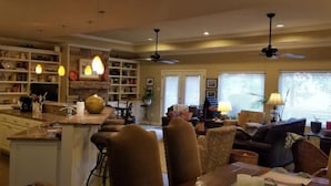A spacious living area with a kitchen, dining area, and a large window providing natural light.