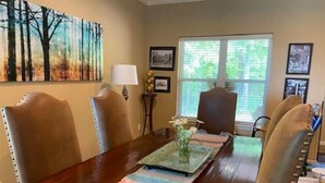 A dining area with a wooden table, striped placemats, and chairs.