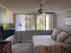 Relax in comfort with a large bed, flat-screen TV, and ceiling fan.