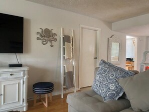 Cozy living space with a flat-screen TV, comfortable sofa, and decorative octopus art.