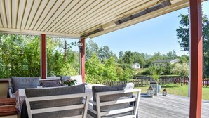 A covered outdoor seating area with a view of a residential neighborhood.
