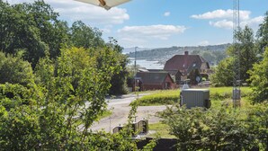 A view of a rural area with a house, trees, and a body of water. - Pet friendly apartment in Allinge (Allinge)