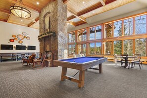 Relax in a spacious room with a pool table, comfortable seating, and a fireplace.