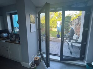 Eine Küche mit einer Schiebetür zu einem Außenbereich mit Terrasse.
