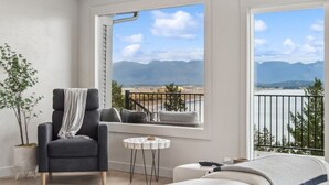 A balcony with a view of mountains and a body of water.