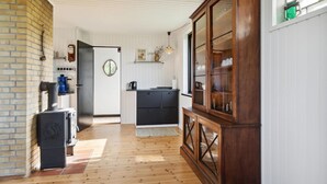 A kitchen with a wooden cabinet, a coffee machine, and a door with a mirror.