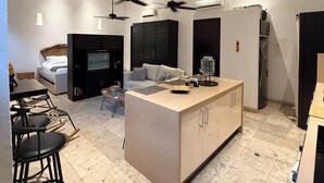 Una cocina moderna con una isla central, armarios negros y un ventilador de techo.
