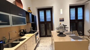 Una cocina moderna con una isla central, puertas dobles y un comedor.