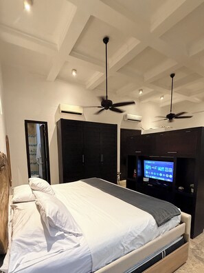 A modern bedroom with a bed, ceiling fans, a TV, and built-in wardrobes. - Loft en Casa Colonial del Centro Histórico. (Cartagena de Indias)