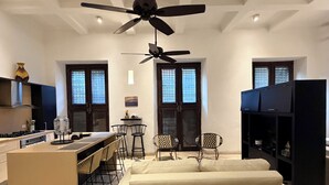 Une cuisine moderne dotée d’un îlot central, de tabourets de bar et d’un ventilateur de plafond.