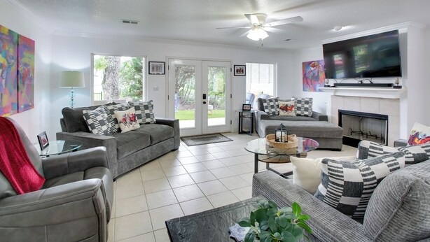 A modern living room with grey sofas, a flat-screen TV, and a fireplace. - Hot Springs Retreat w/ Fireplace on Lake! (Hot Springs)