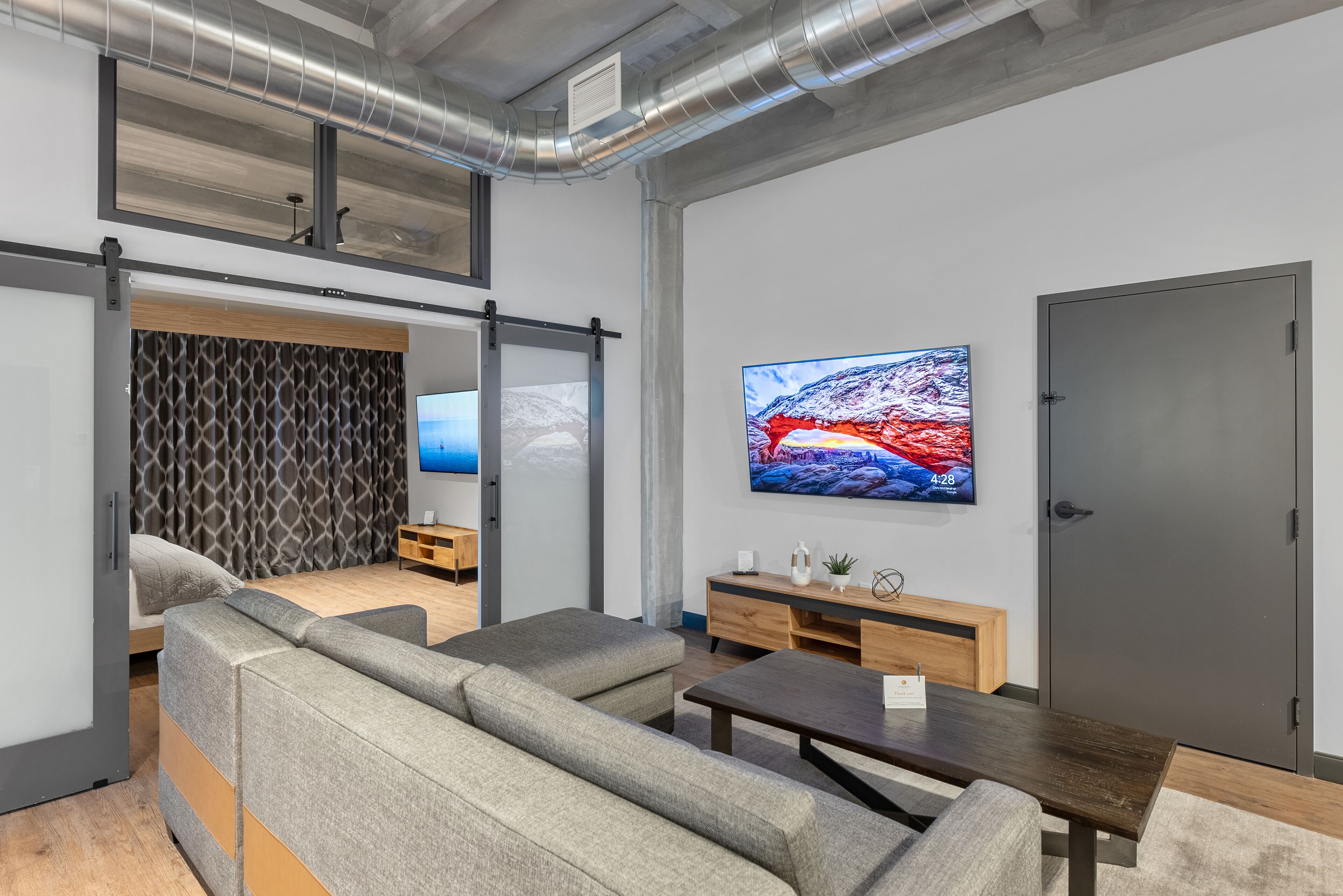 Una sala de estar moderna con un sofá, una mesa de centro y un televisor montado en la pared.