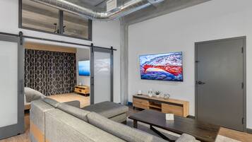 Una sala de estar moderna con un sofá, una mesa de centro y un televisor montado en la pared.