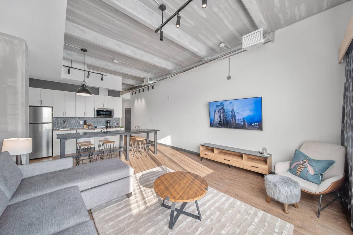 A modern living space with a kitchen, dining area, and seating area.