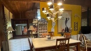 Un comedor con suelo a cuadros, una mesa de madera y sillas. Hay un candelabro sobre la mesa.
