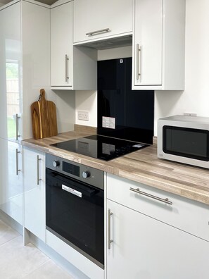 Enjoy cooking in this well-equipped kitchen with microwave, stainless steel oven, and ample countertop space.