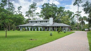 A two-story house with a paved driveway and a well-maintained lawn. - Little Ranches Retreat in the Heart of Equestrian Community  (Wellington)