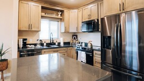 A modern kitchen with wooden cabinets, stainless steel appliances, and a central island.