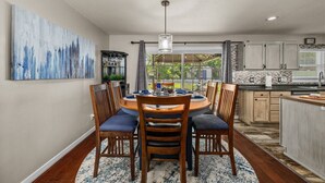 Un coin repas avec une table ronde, des chaises et une vue sur le jardin.