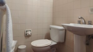 A bathroom with a toilet, sink, and towel rack. - Hotel RustiCall (La Paz)