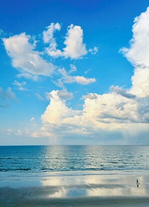 Een strand met een heldere lucht en rustige zee.
