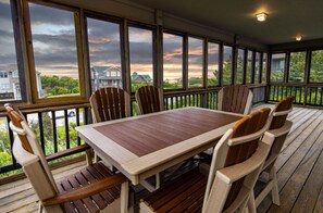 Enjoy expansive views of the neighborhood from this covered outdoor space with a wooden deck and comfortable seating for six.