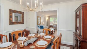 A dining room with a wooden table set for six, a chandelier, and a large mirror on the wall. - Swamp Fox Retreat in Historic Willowbank Neighborhood.15 minutes to PI.  (Georgetown)