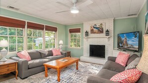 A living room with a fireplace, two sofas, a coffee table, and a television. - Swamp Fox Retreat in Historic Willowbank Neighborhood.15 minutes to PI.  (Georgetown)