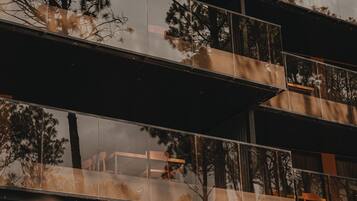 A multi-story building with balconies and reflective glass windows.