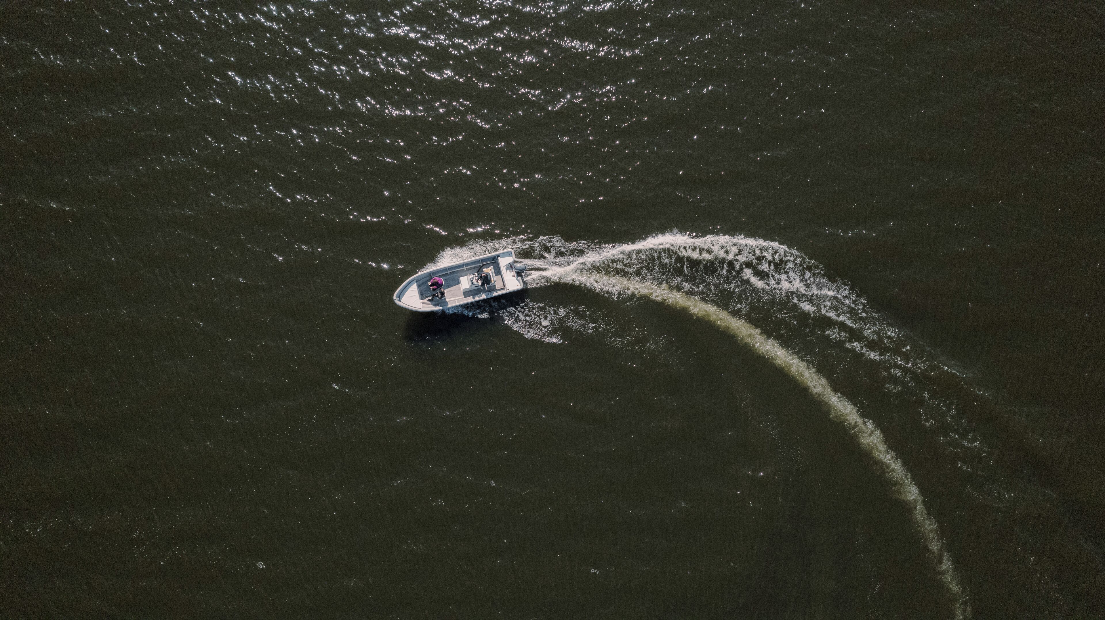 An aerial view of a boat creating a wake in the water.