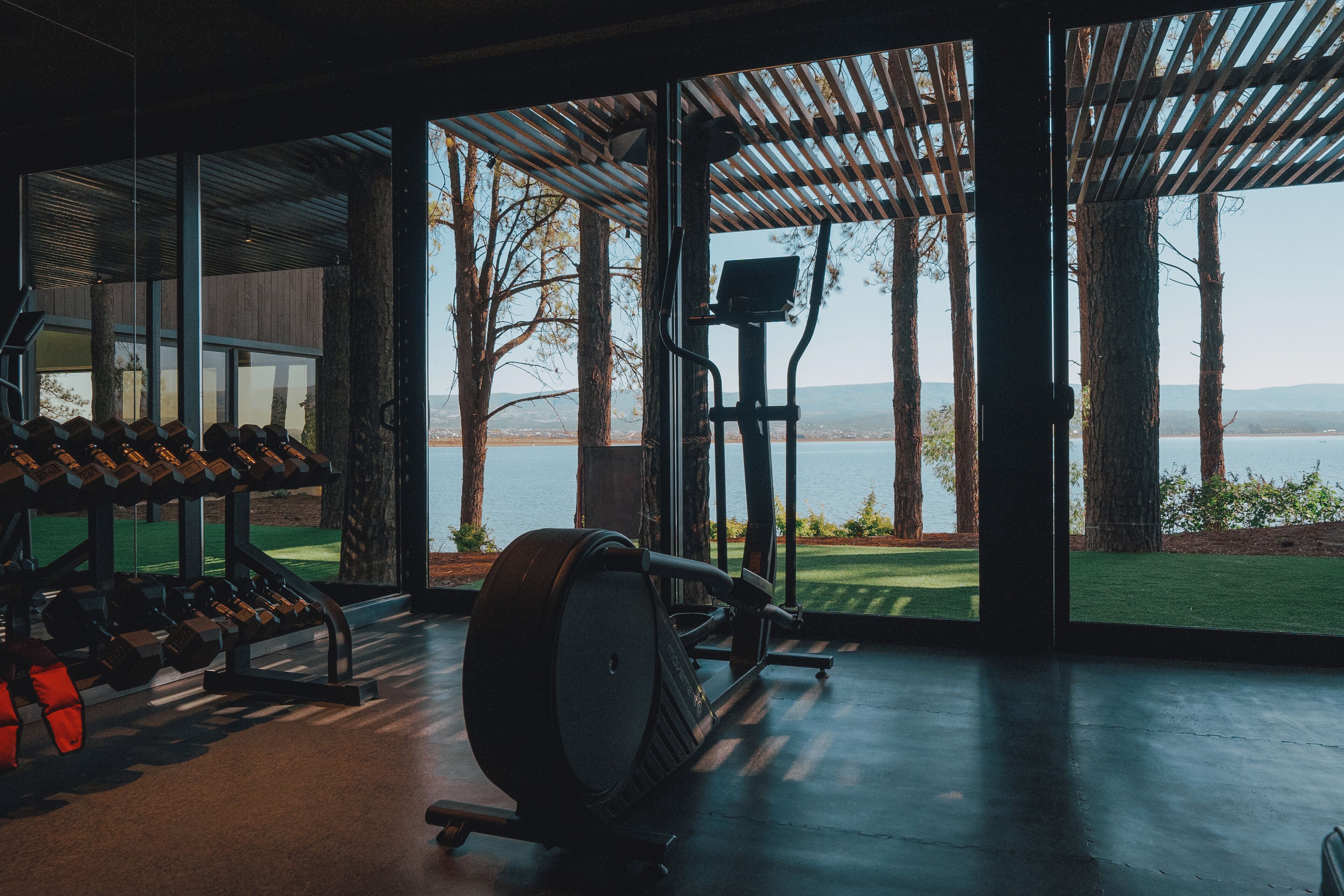 A gym with exercise equipment and a view of a lake.
